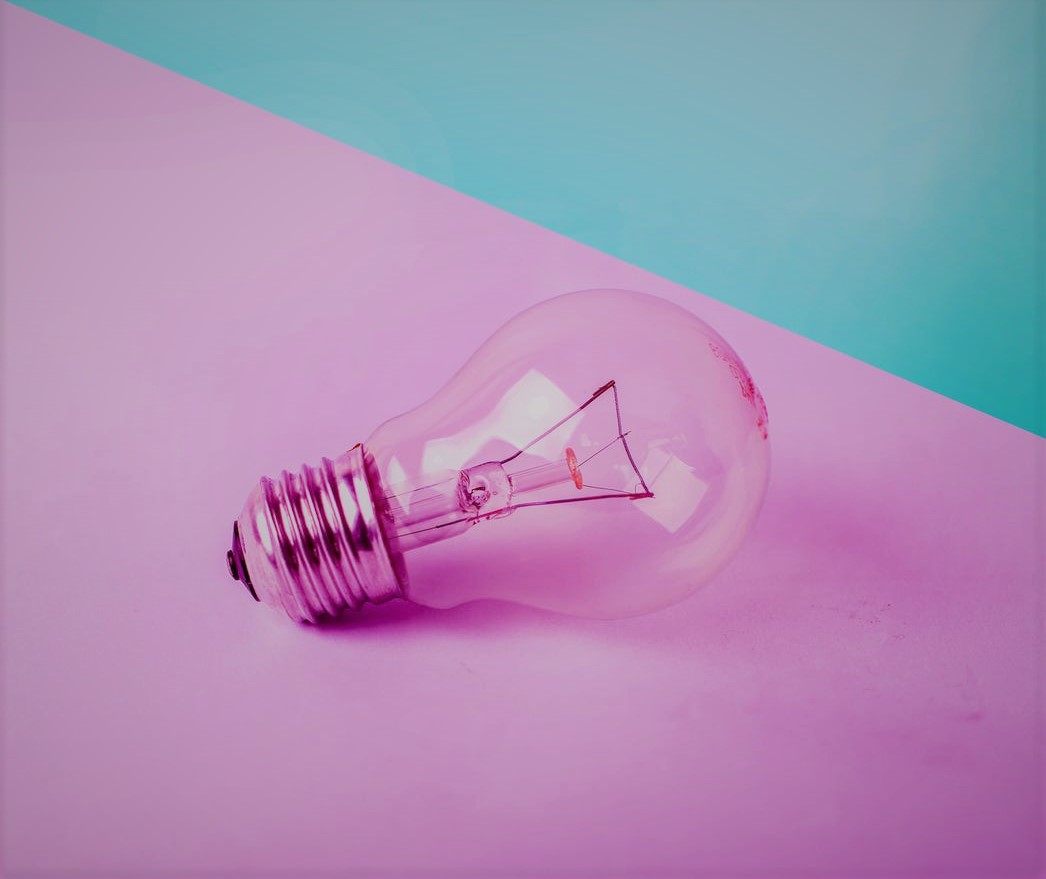 a clear lightbulb on a pink background