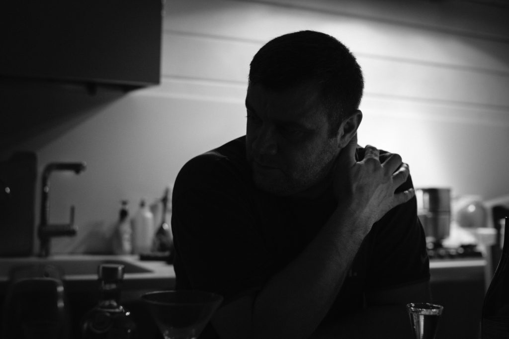 man sitting alone at a table in a kitchen