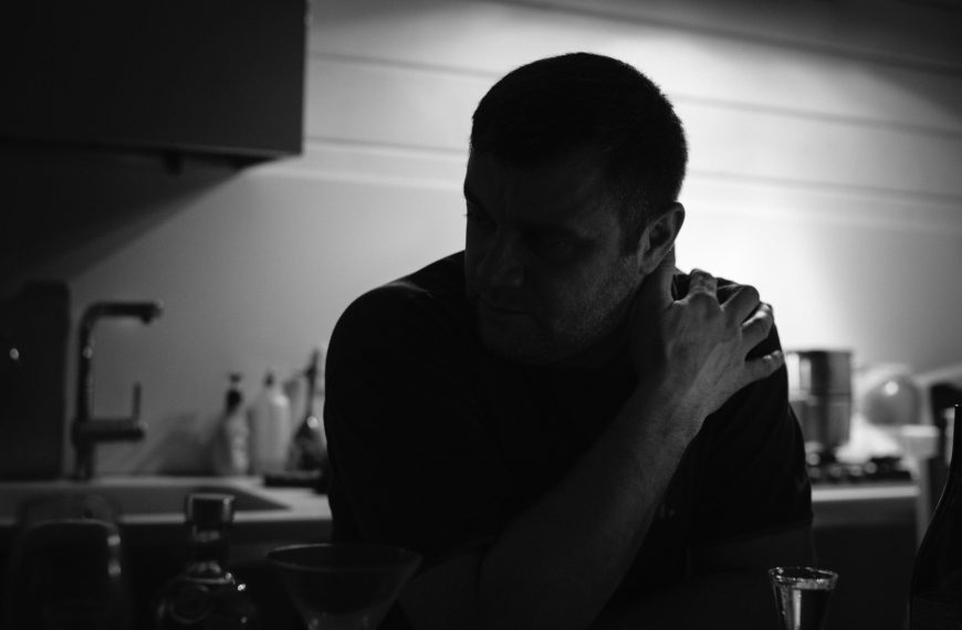 man sitting alone at a table in a kitchen