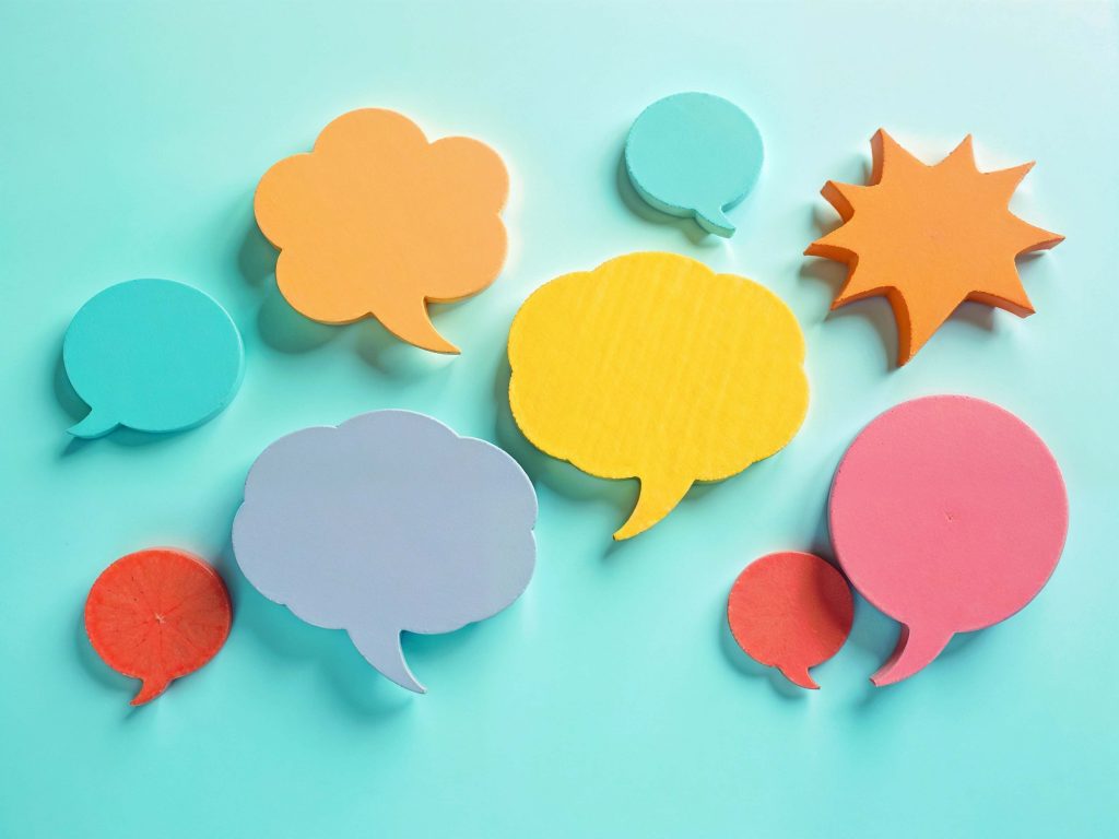 Scattered Post It notes in the shape of speech bubbles