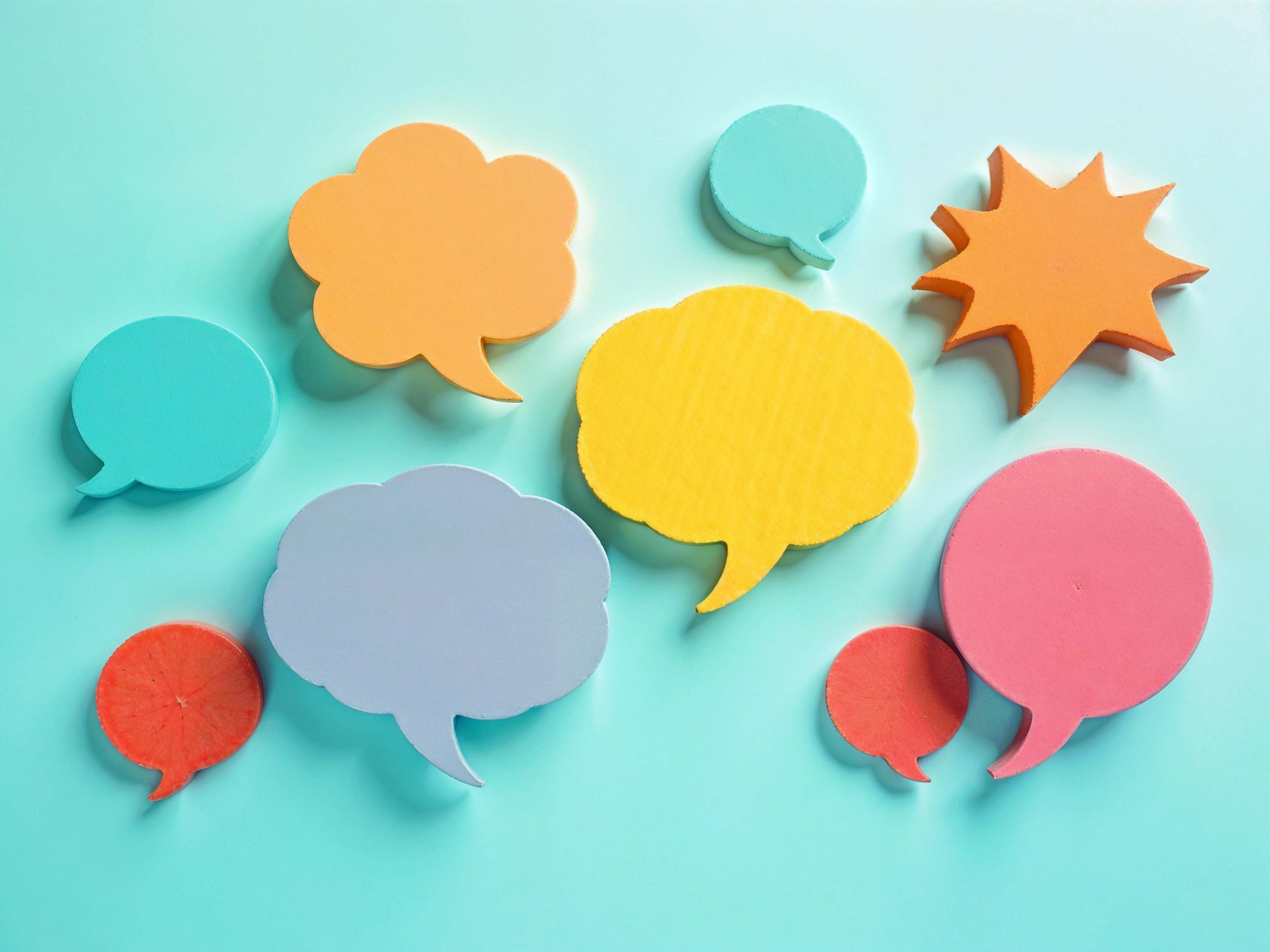 Scattered Post It notes in the shape of speech bubbles