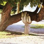 hand sculpture holding up a tree branch